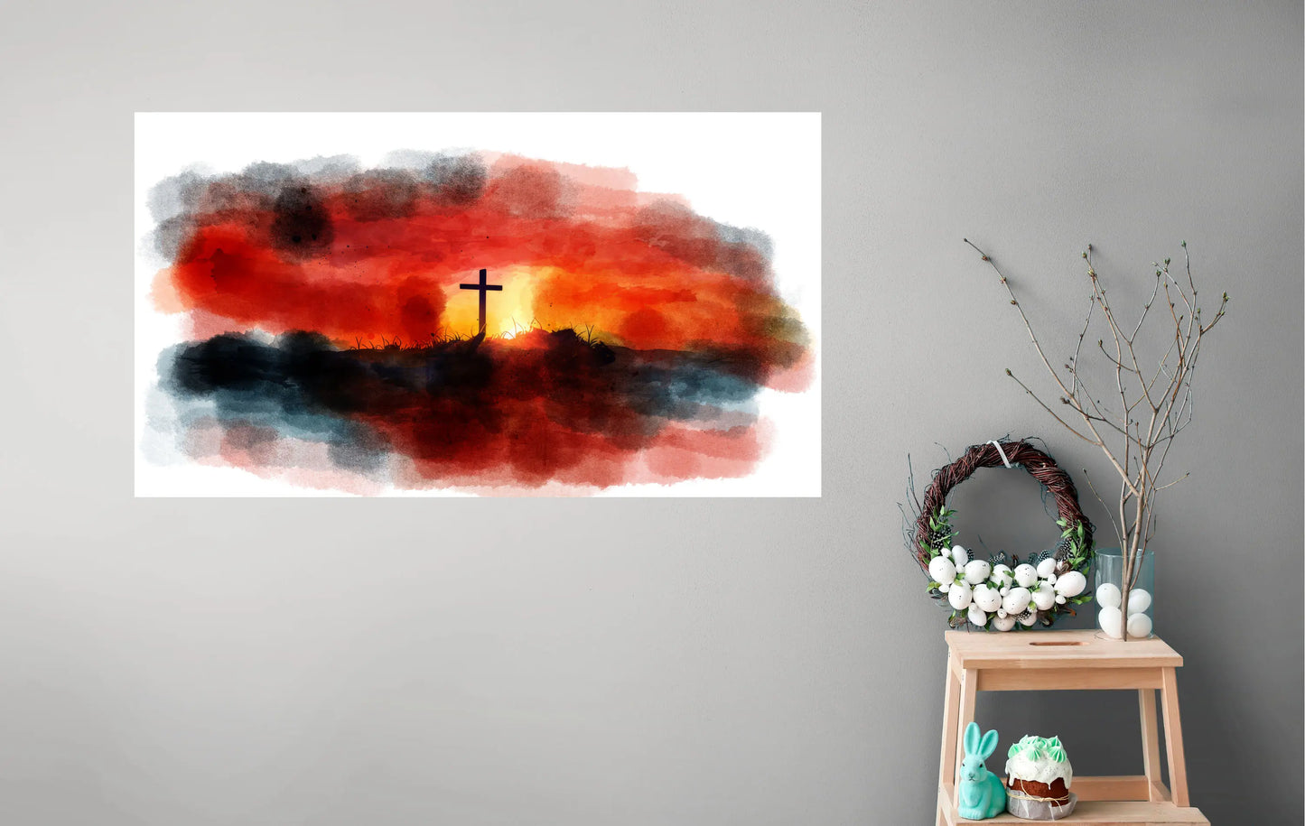 Artistic depiction of a cross against a sunset sky with decorative items on a small table below.