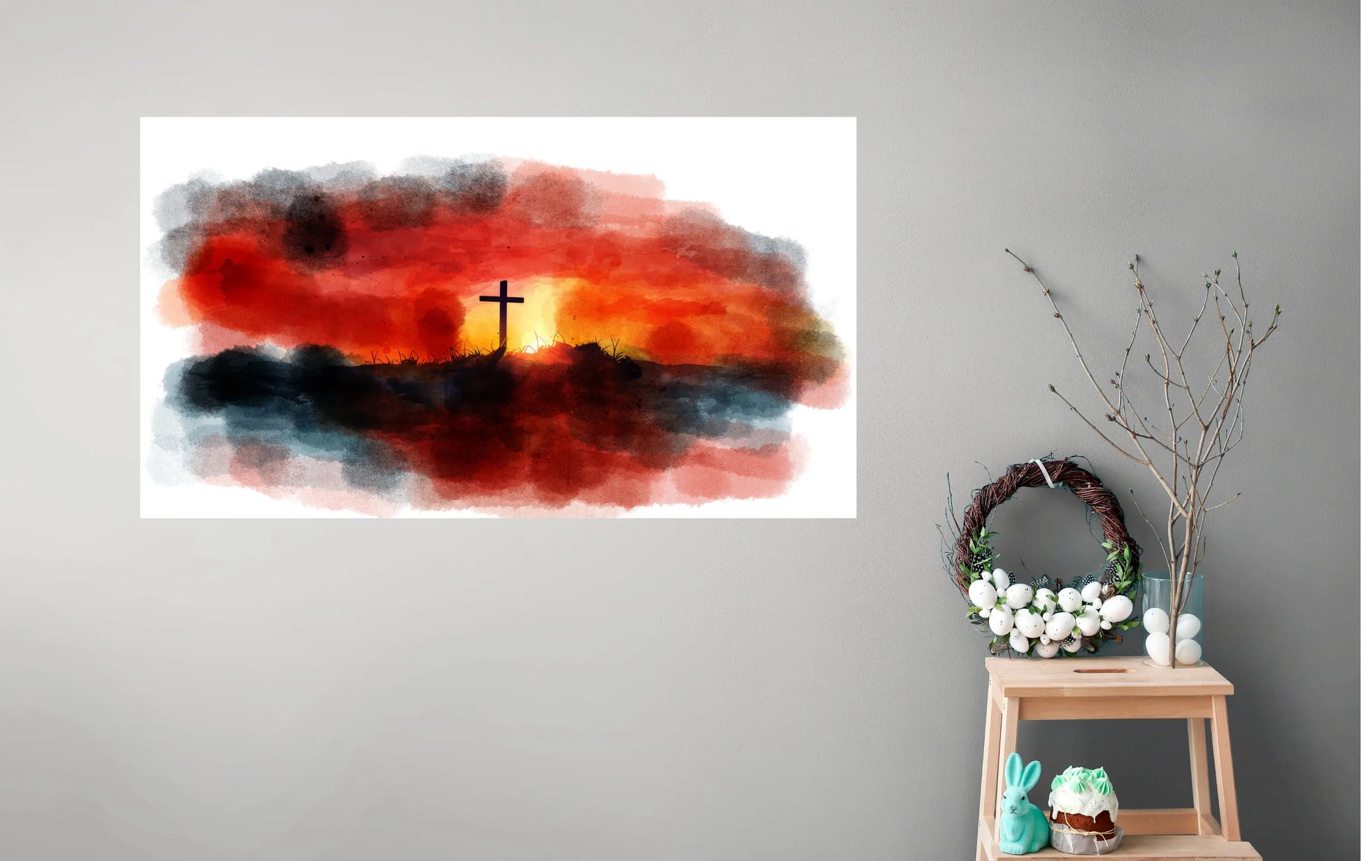 Artistic depiction of a cross against a sunset sky with decorative items on a small table below.
