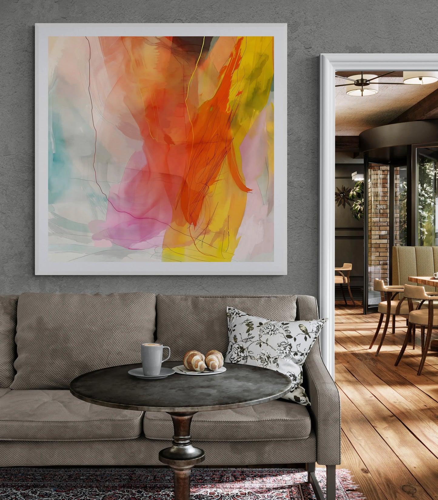 Living room with a gray sofa, round wooden table, and abstract painting on the wall.