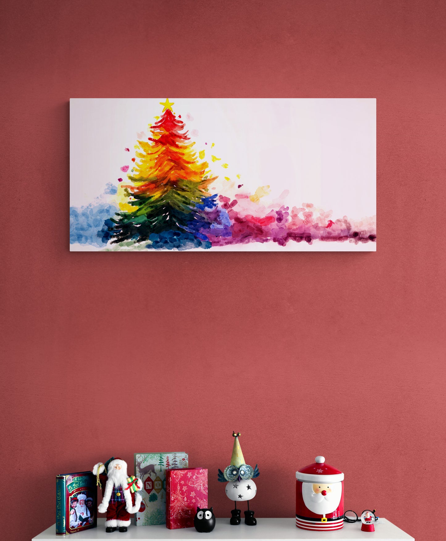 Colorful abstract Christmas tree painting on a red wall with decorative items below.