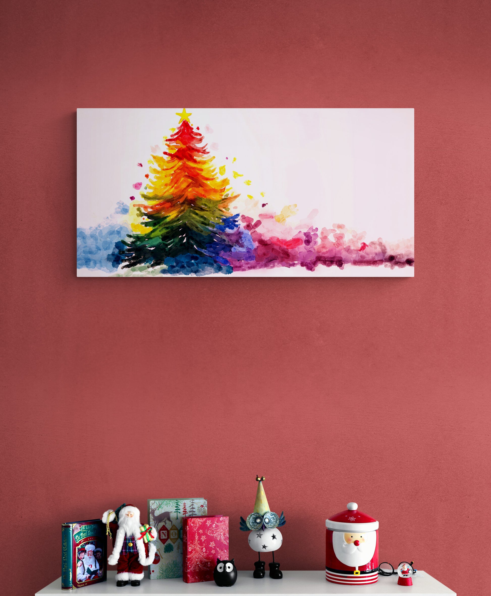 Colorful abstract Christmas tree painting on a red wall with decorative items below.