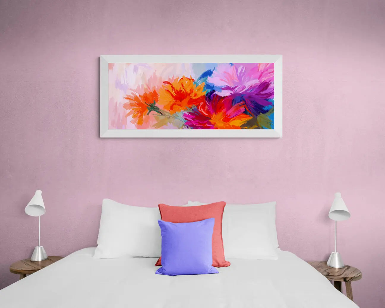 Colorful floral artwork on a pink wall above a bed with colorful pillows.