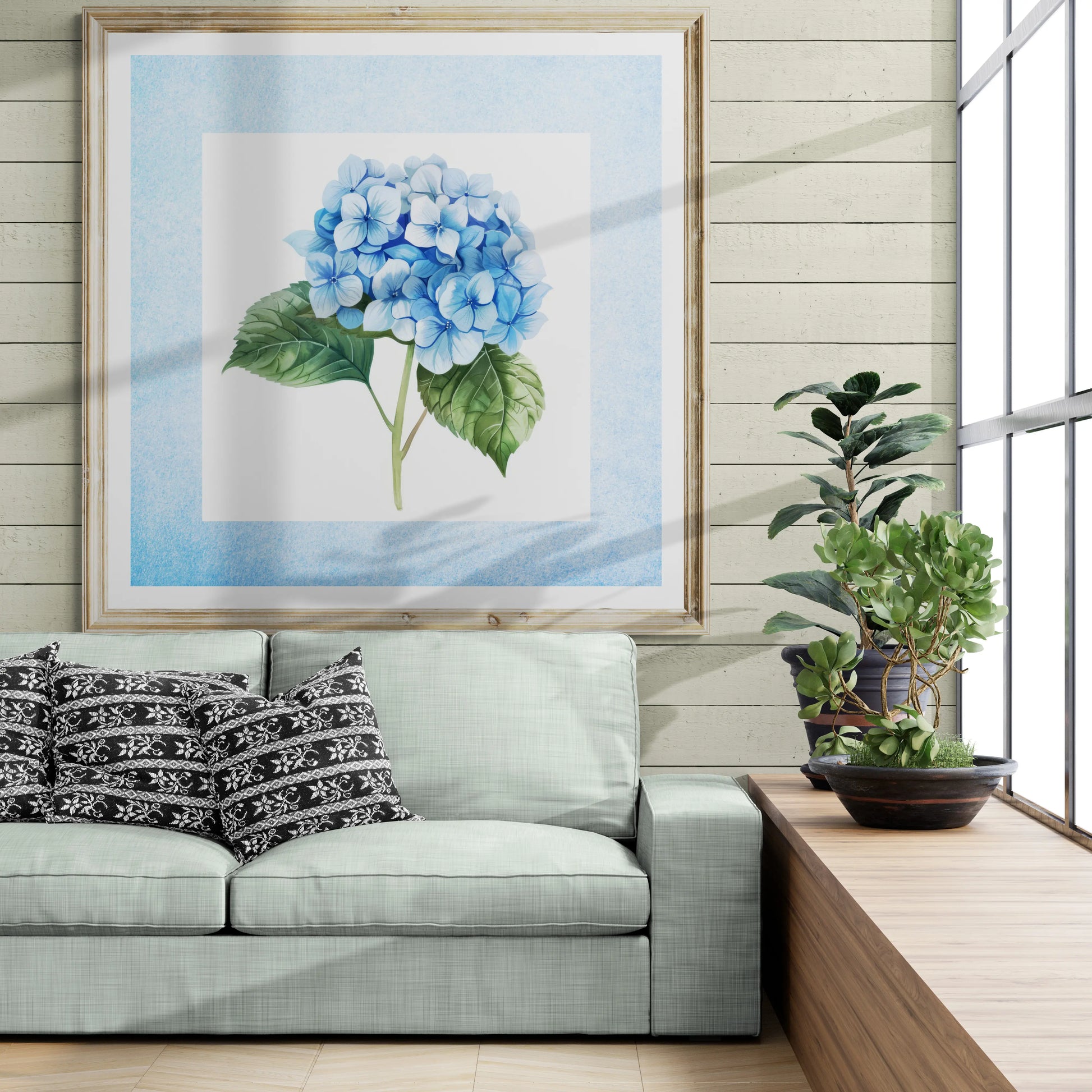 Living room with a gray sofa, decorative pillows, and a framed blue flower print on the wall.